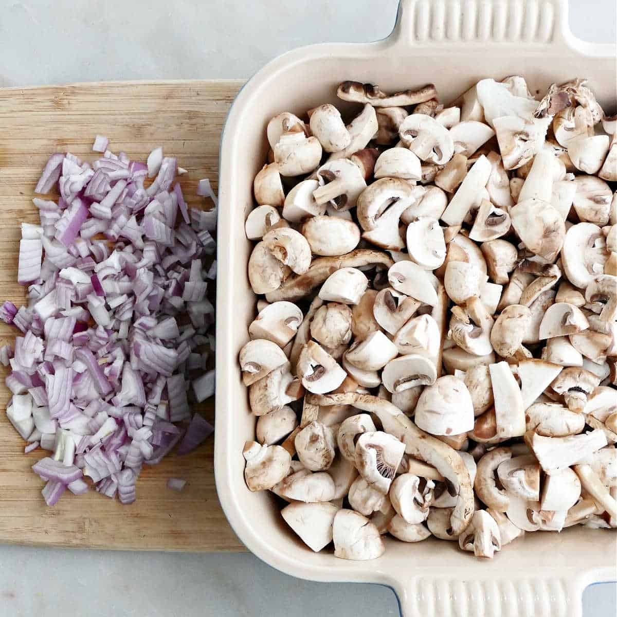 sliced mushrooms and shallots on a cutting board