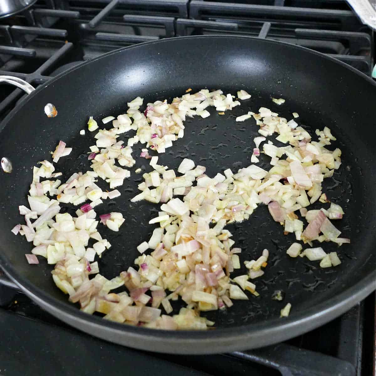 chopped shallots cooking in olive oil in a skillet