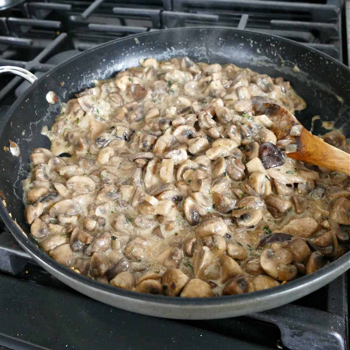 mushrooms cooking with Greek yogurt and flour in a skillet