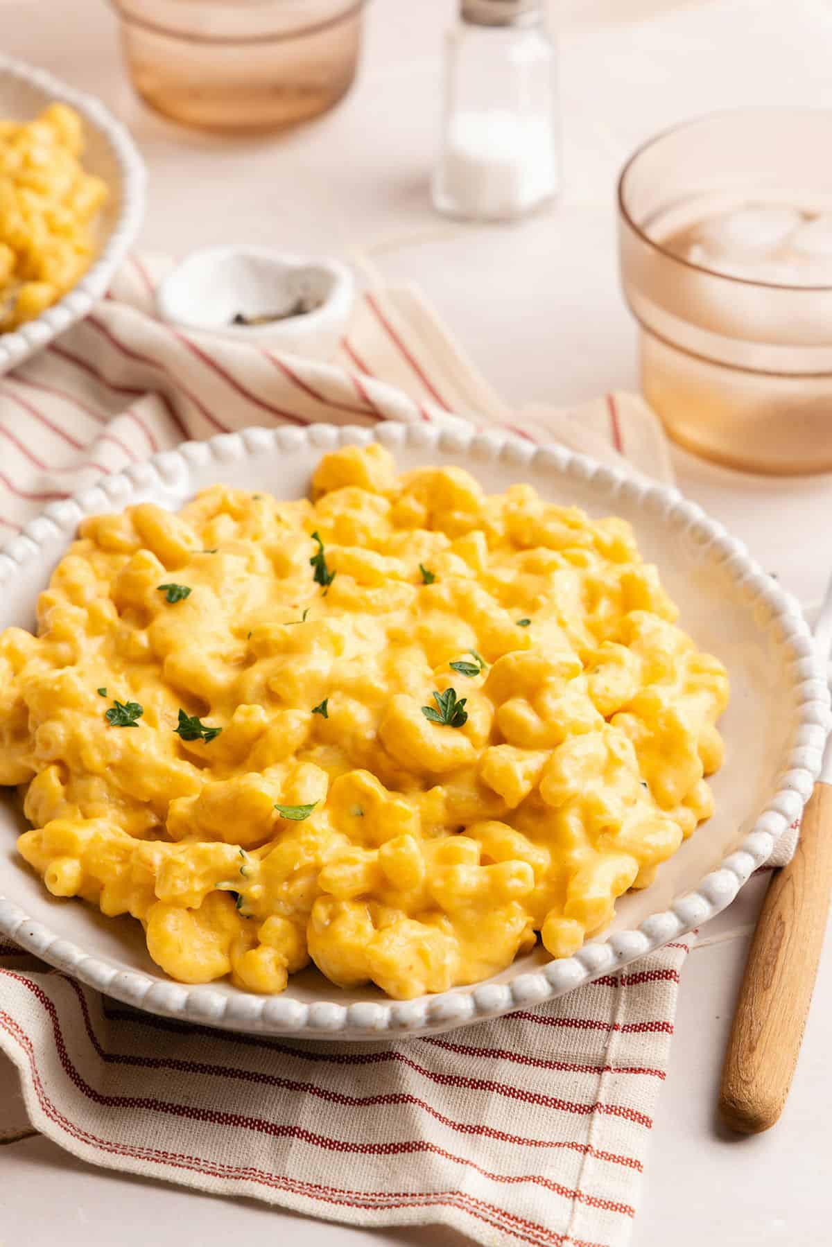 Hidden veggie mac and cheese on a plate in front of water glasses.