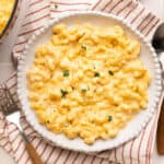 Veggie mac and cheese on a plate on a red striped napkin next to a fork.