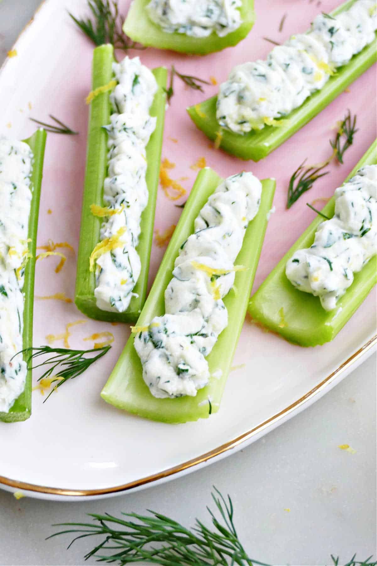 celery sticks with mascarpone cheese, herbs, and lemon on a serving tray