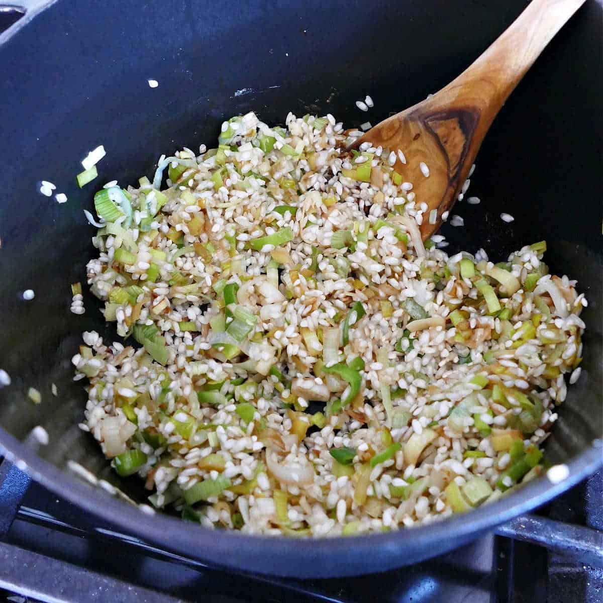 leeks and arborio rice cooking in a soup pot on a stove