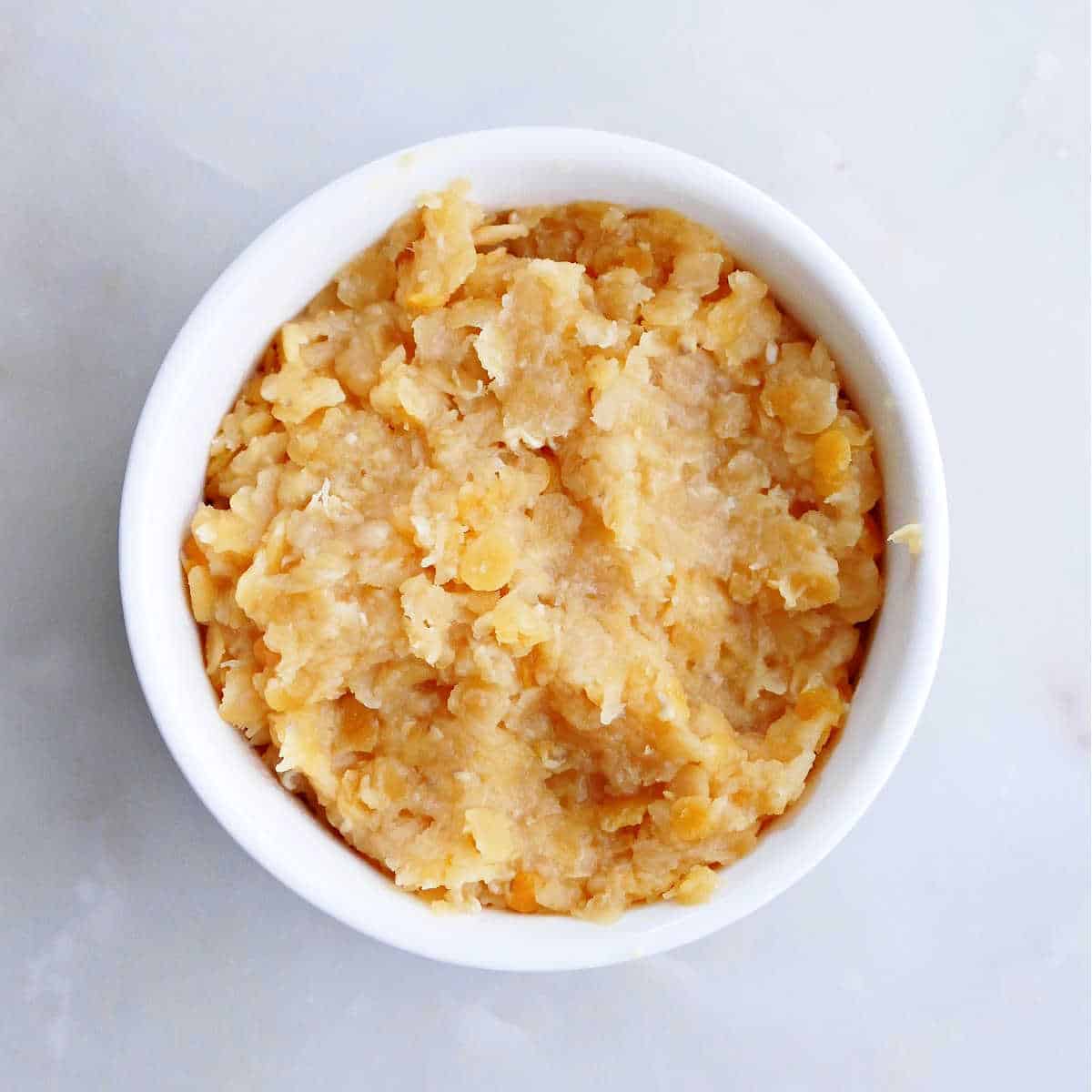 cooked red lentils with a mushy texture in a small bowl on a counter