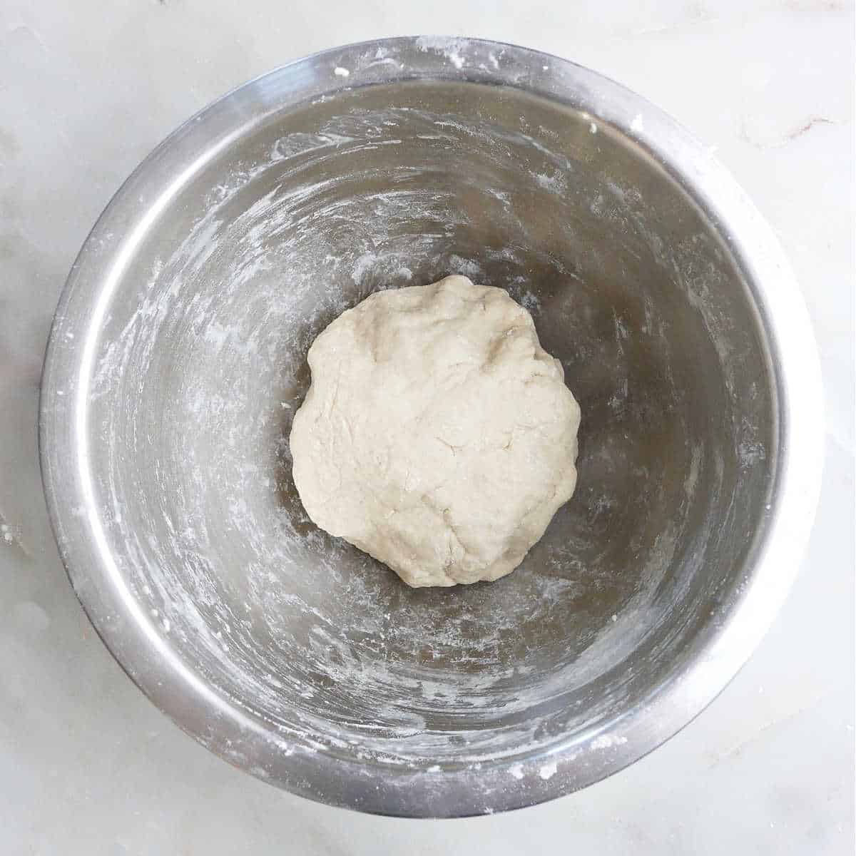 a ball of dough for leek pancakes in a mixing bowl