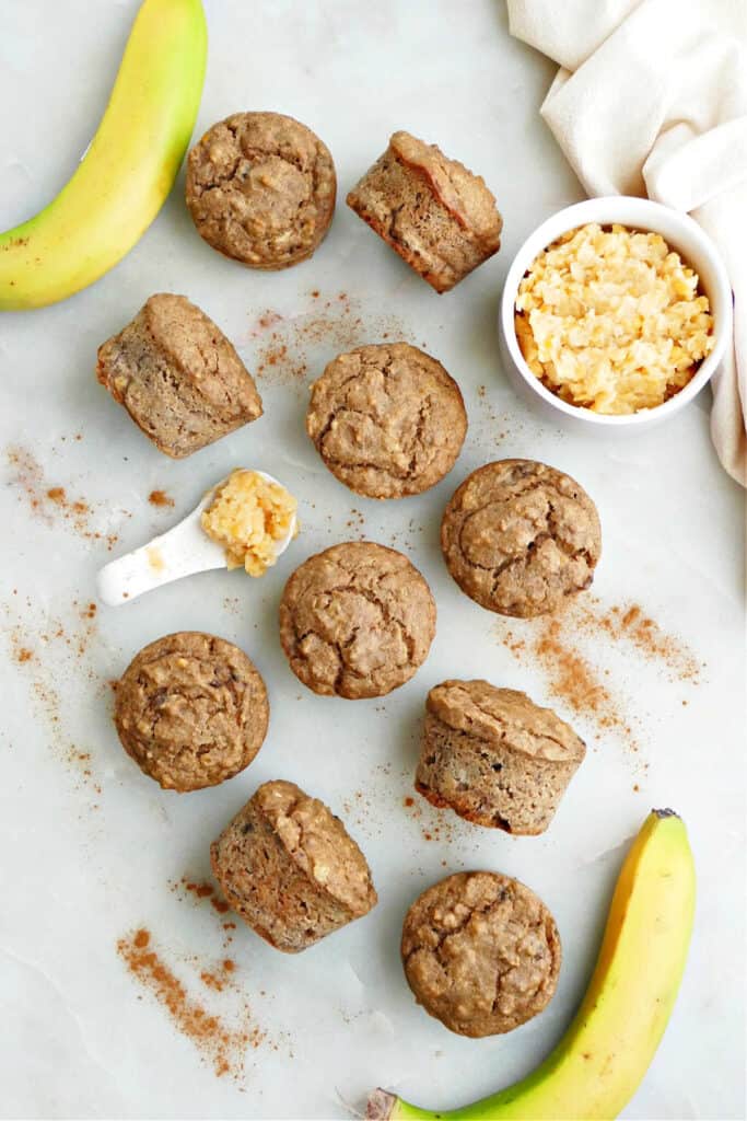 10 lentil muffins next to each other on a counter with lentil puree and bananas