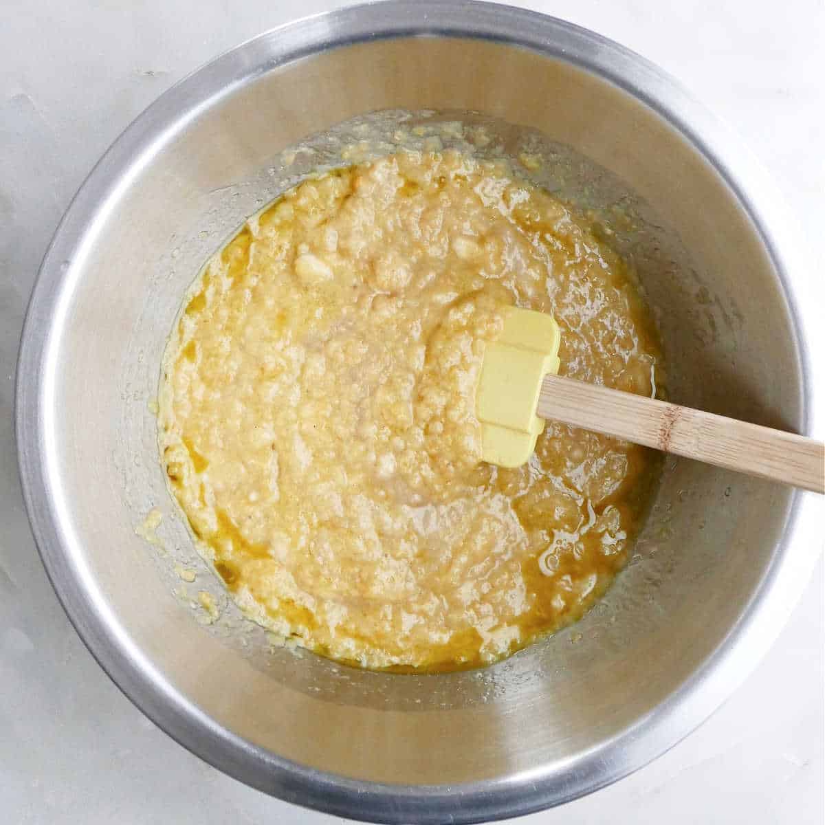 wet ingredients for banana lentil muffins mixed together with a rubber spatula in a bowl