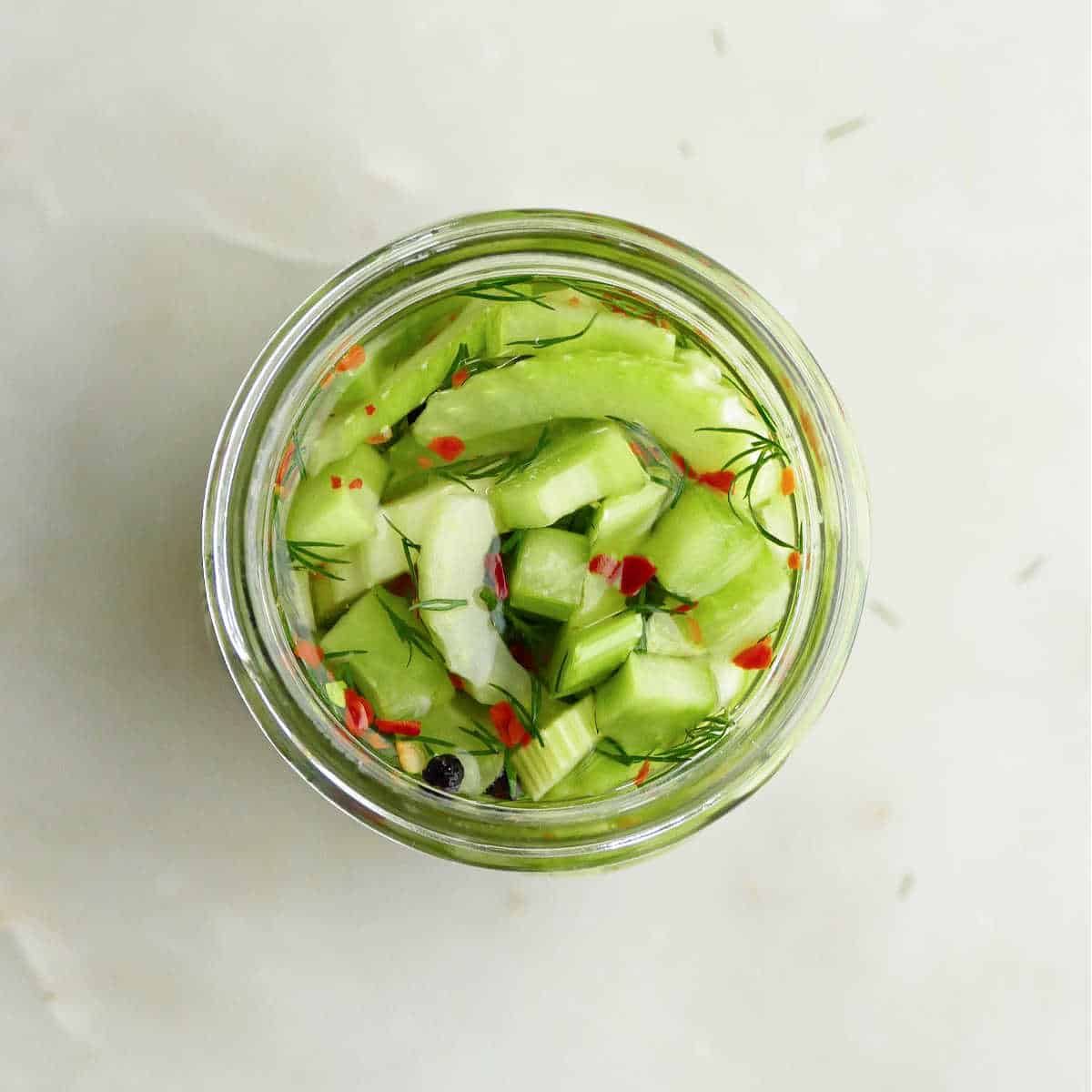 sliced celery stuffed into a glass jar with brine poured on top