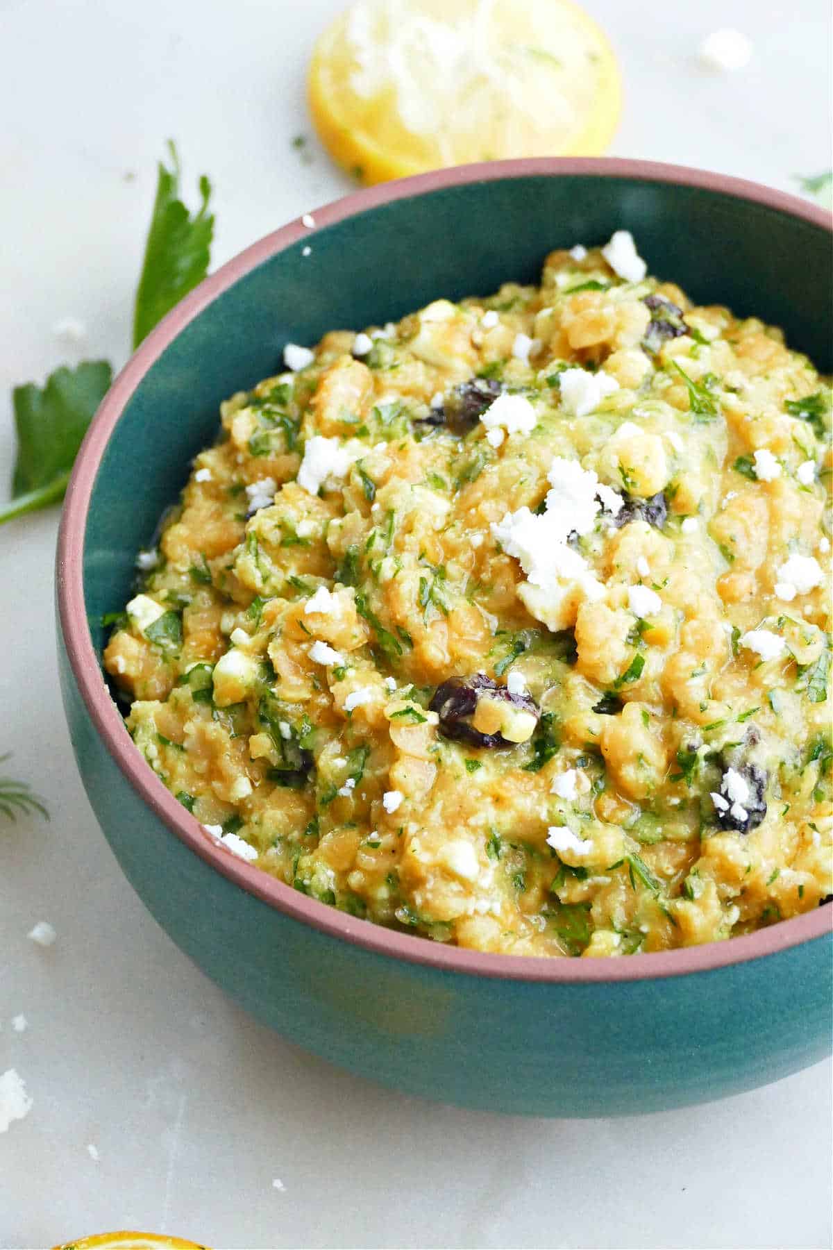 lentil and herb salad topped with crumbled feta cheese in a bowl