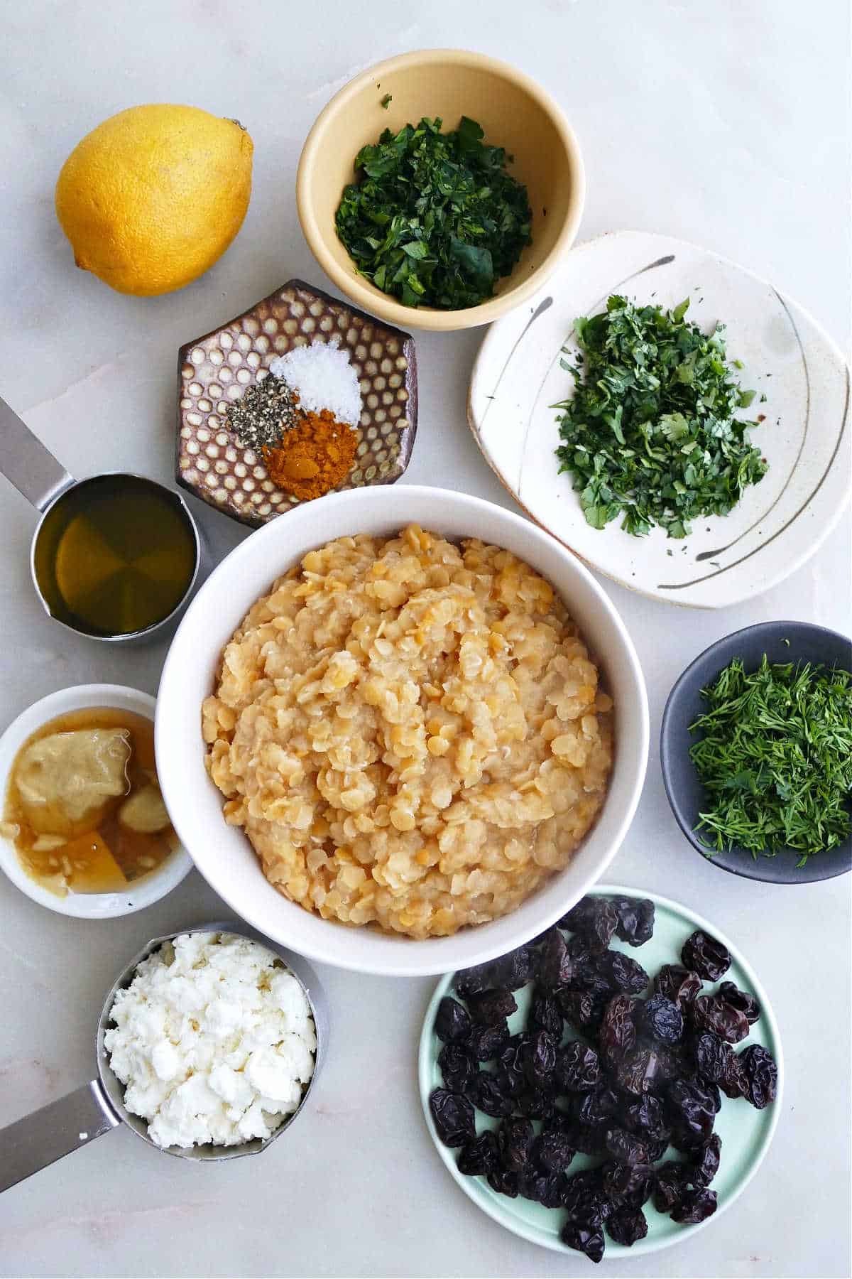lemon, dill, parsley, cilantro, raisins, feta, red lentils, honey, and spices on a counter