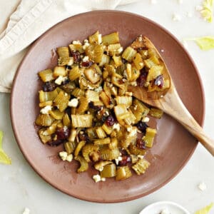 roasted celery with dates and blue cheese on a plate with a wooden spoon