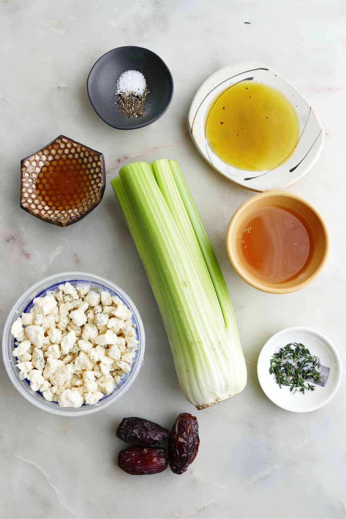 honey, olive oil, broth, seasonings, celery, dates, and blue cheese on a counter