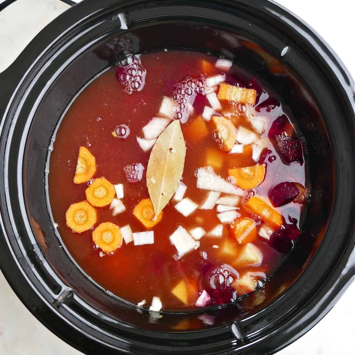 ingredients for borscht in the slow cooker before cooking