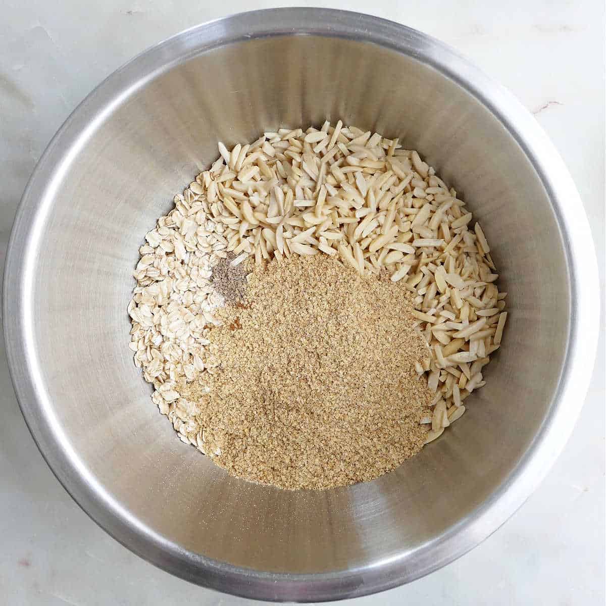 dry ingredients for almond granola in a mixing bowl