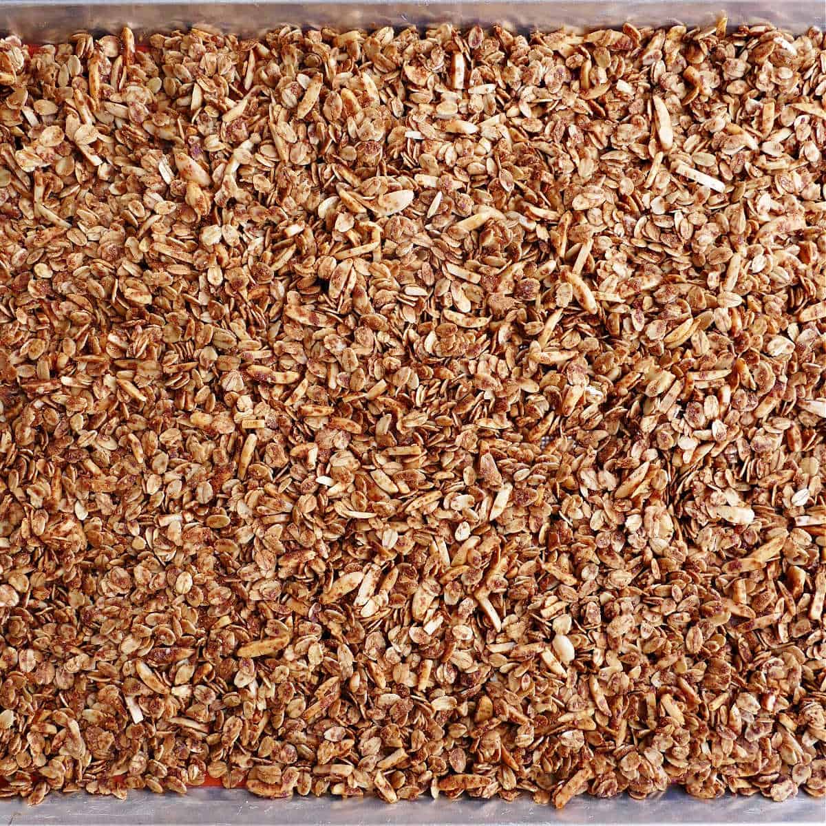 honey granola baked to golden brown on a lined baking sheet