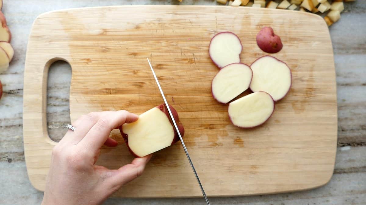woman performing step one of cutting a potato into julienne pieces