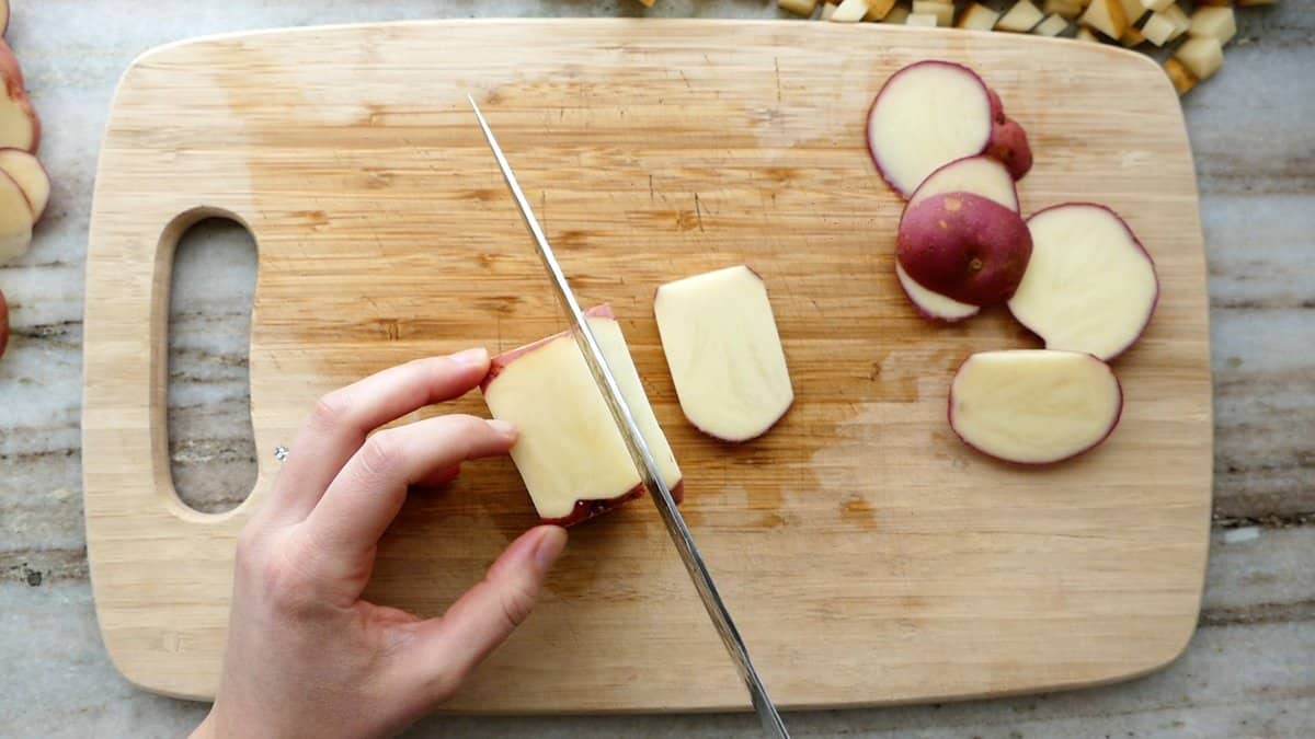 woman performing step two of cutting a potato into julienne pieces