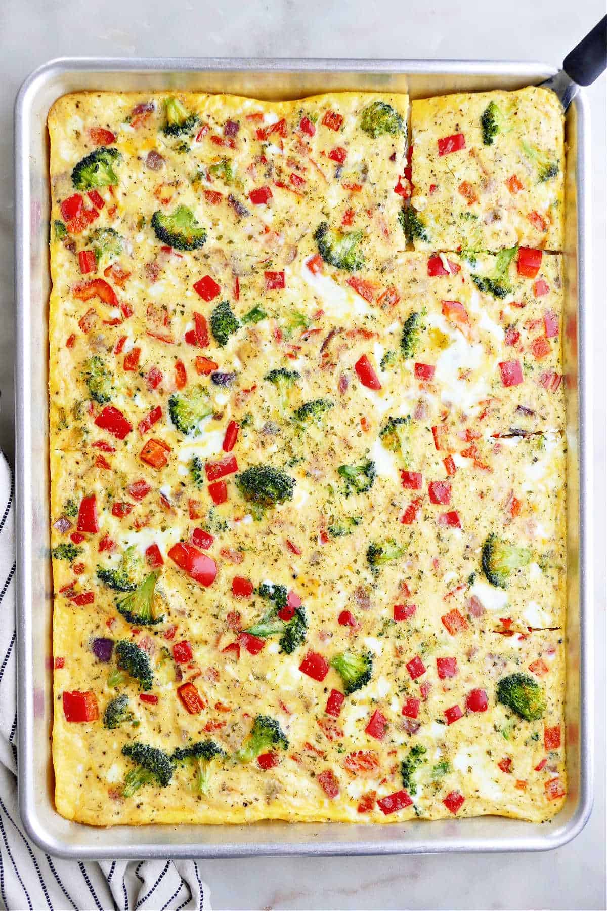 sheet pan omelet with veggies on a half sheet pan on a counter