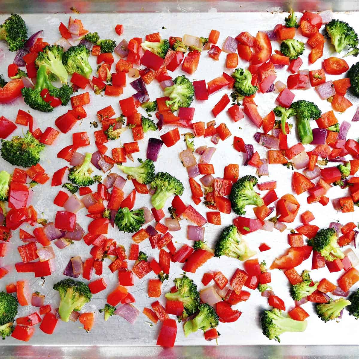 cooked veggies on a half sheet pan sprayed with nonstick spray