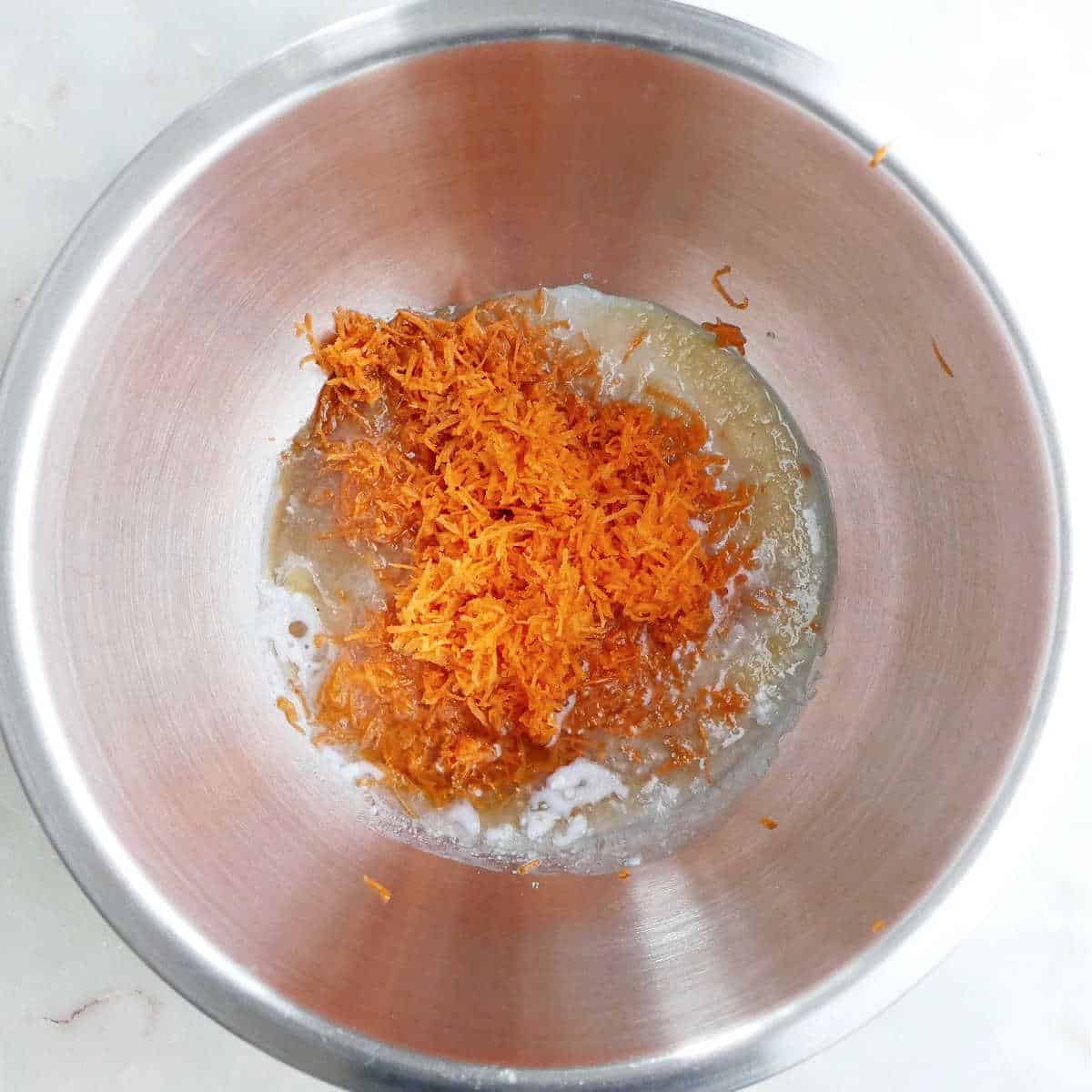 wet ingredients and carrots for cookies in a mixing bowl