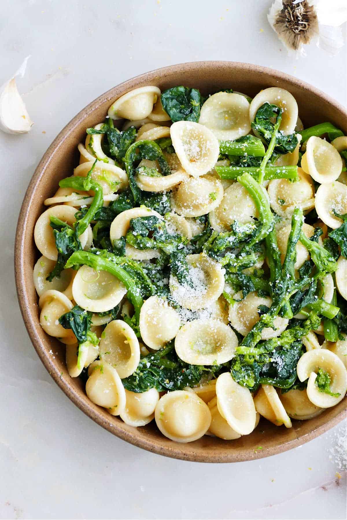 broccoli rabe and orecchiette in a serving bowl sprinkled with cheese