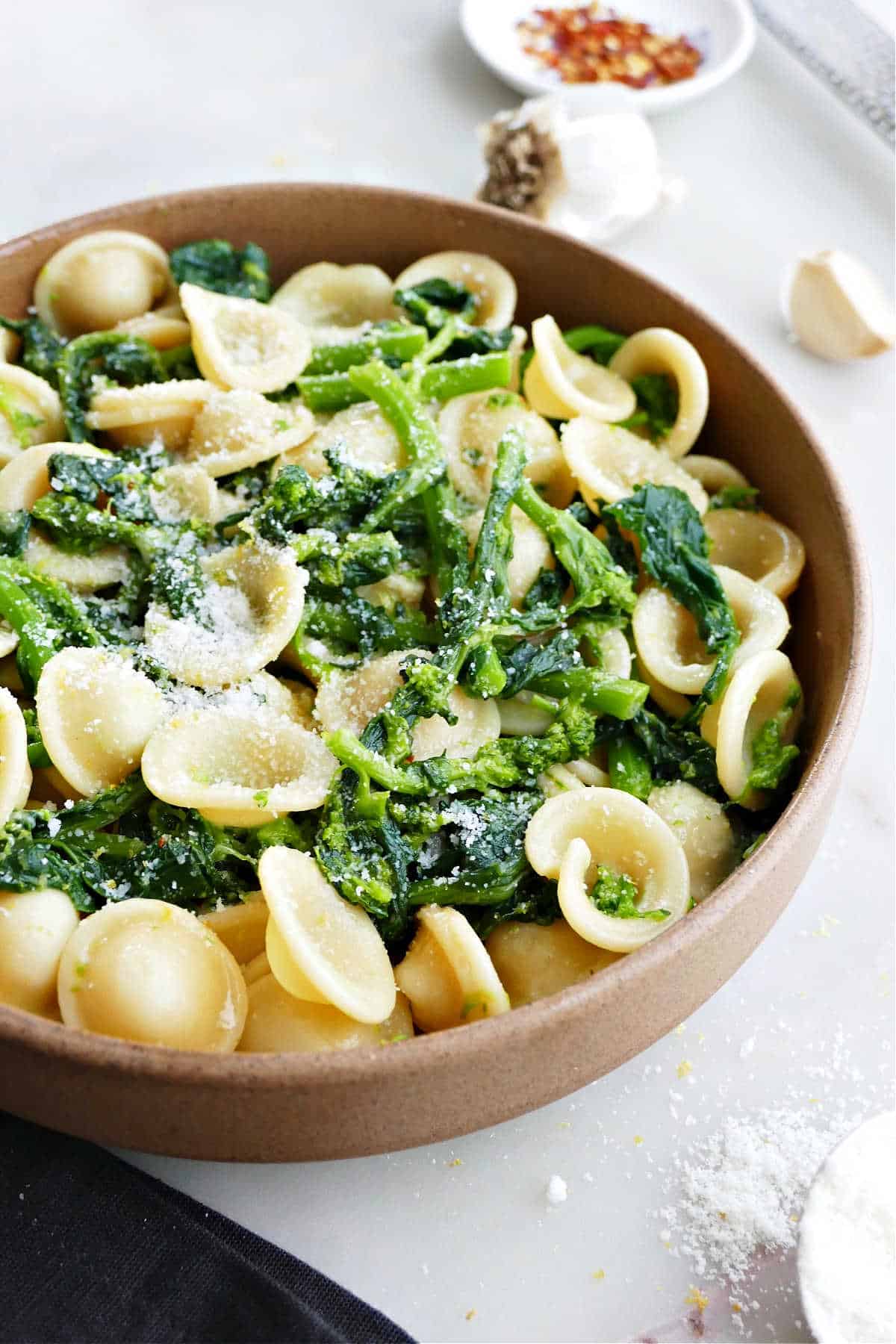 broccoli rabe and orecchiette in a serving bowl sprinkled with cheese