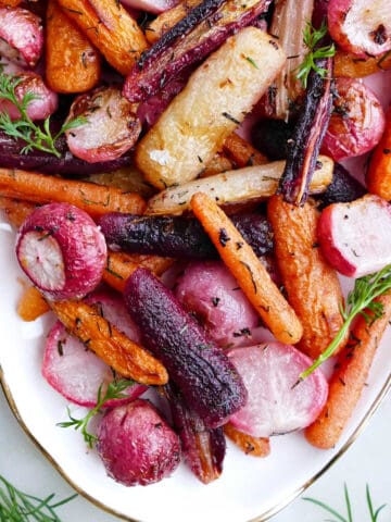 baked radishes and carrots with herbs and butter on a serving tray