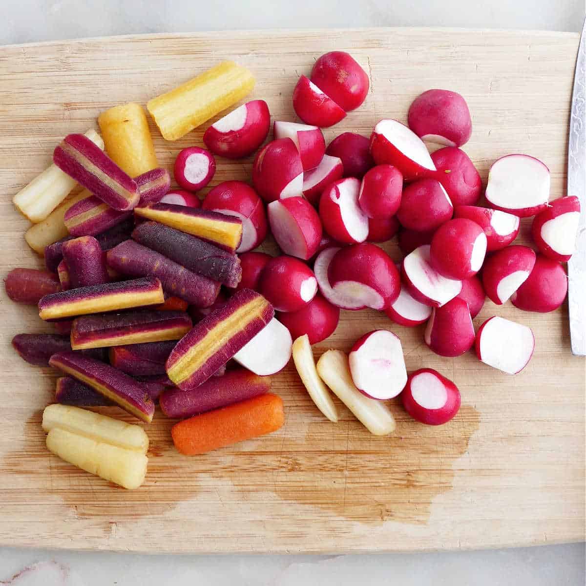 baby carrots and sliced radishes on a cutting board