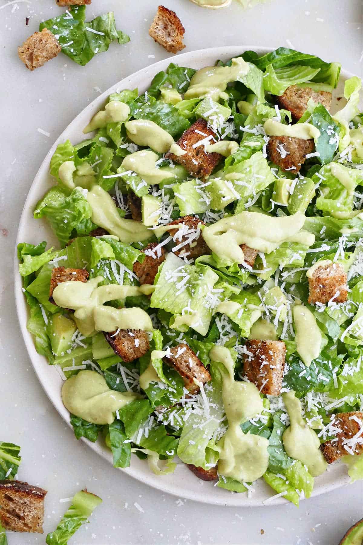 Caesar salad with avocado dressing and croutons on a plate
