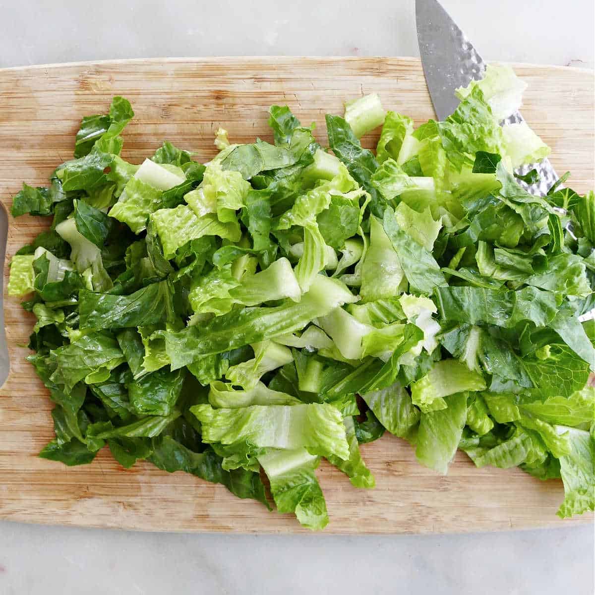 romaine chopped into pieces on a bamboo cutting board