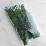 frozen Swiss chard in a sealed plastic bag on a counter