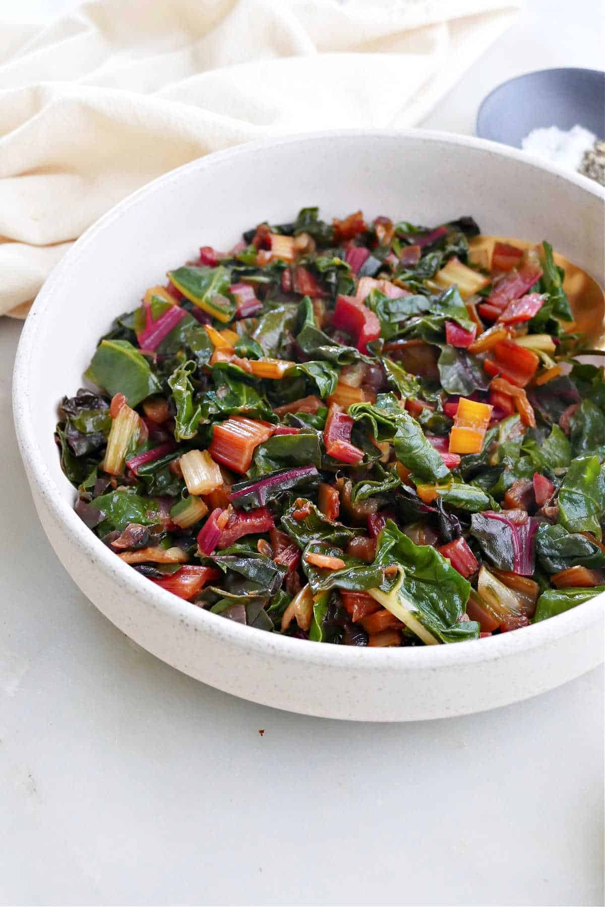 steamed chard leaves and stems in a serving bowl on a counter