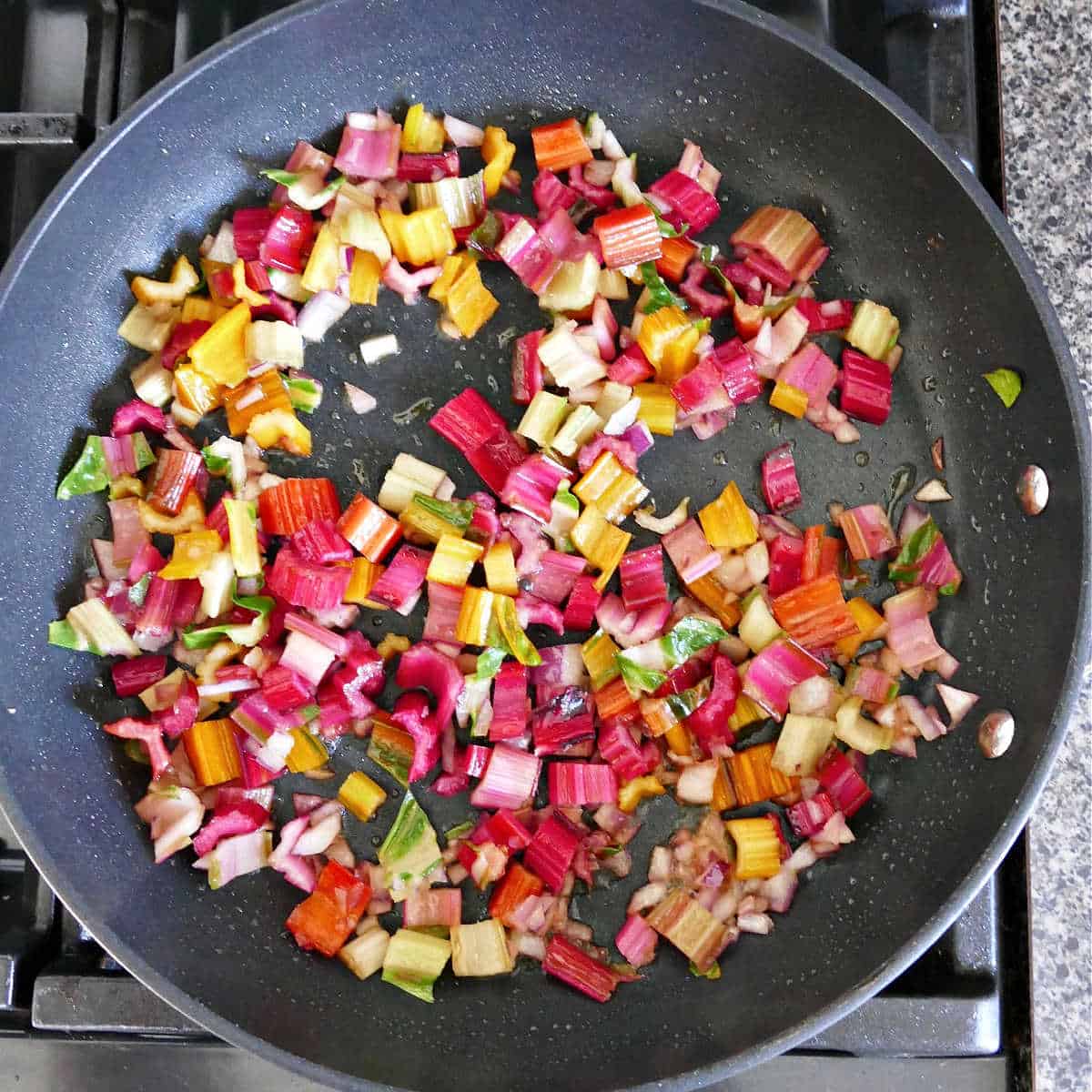 rainbow chard stems cooking in olive oil in a skillet