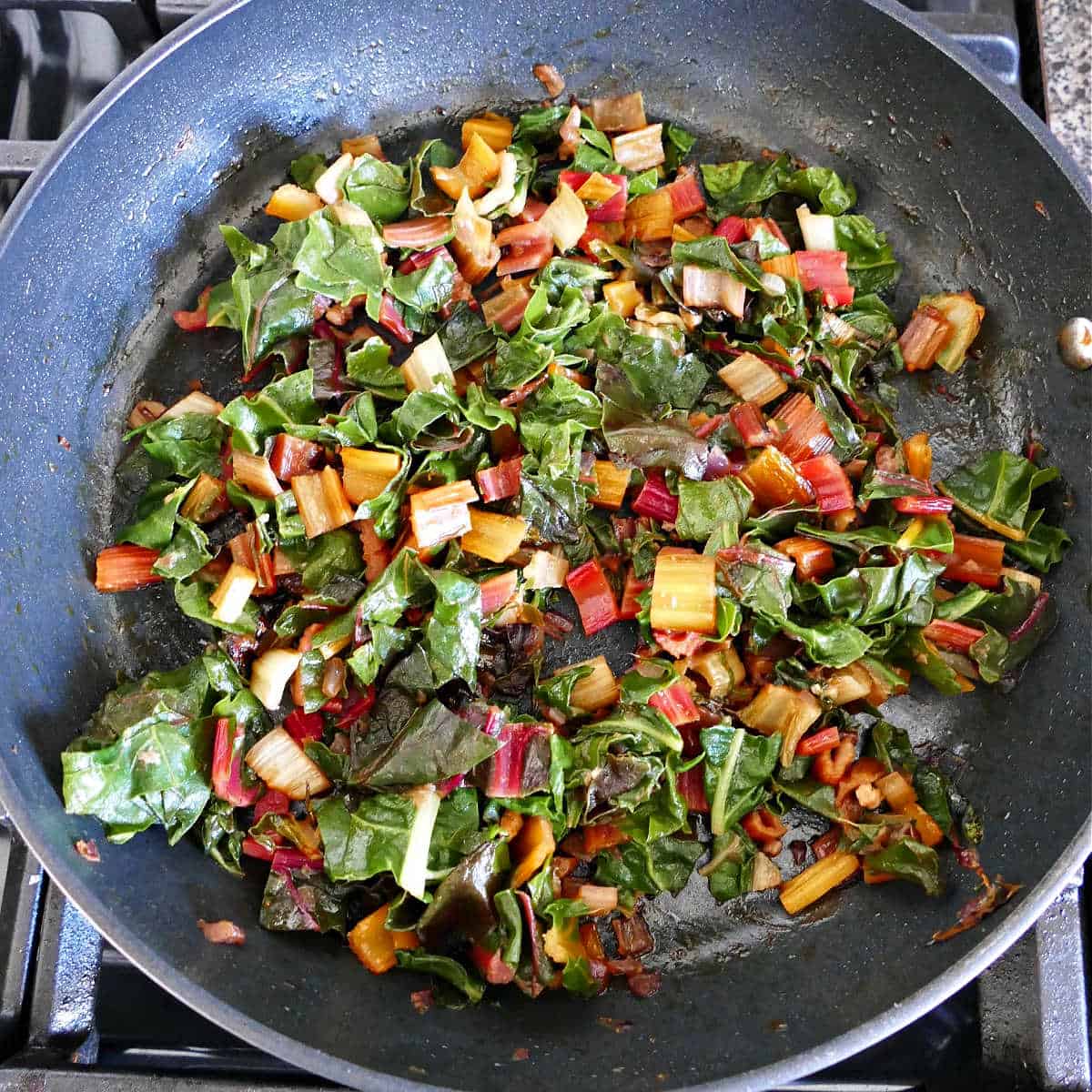 sautéed then steamed Swiss chard cooking in a skillet