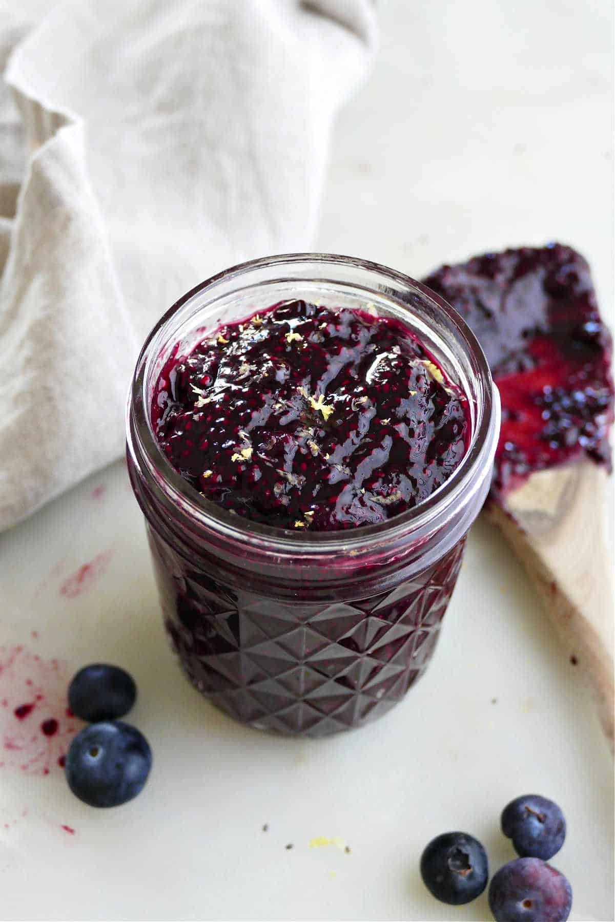 blueberry chia seed jam in a glass jar topped with lemon zest