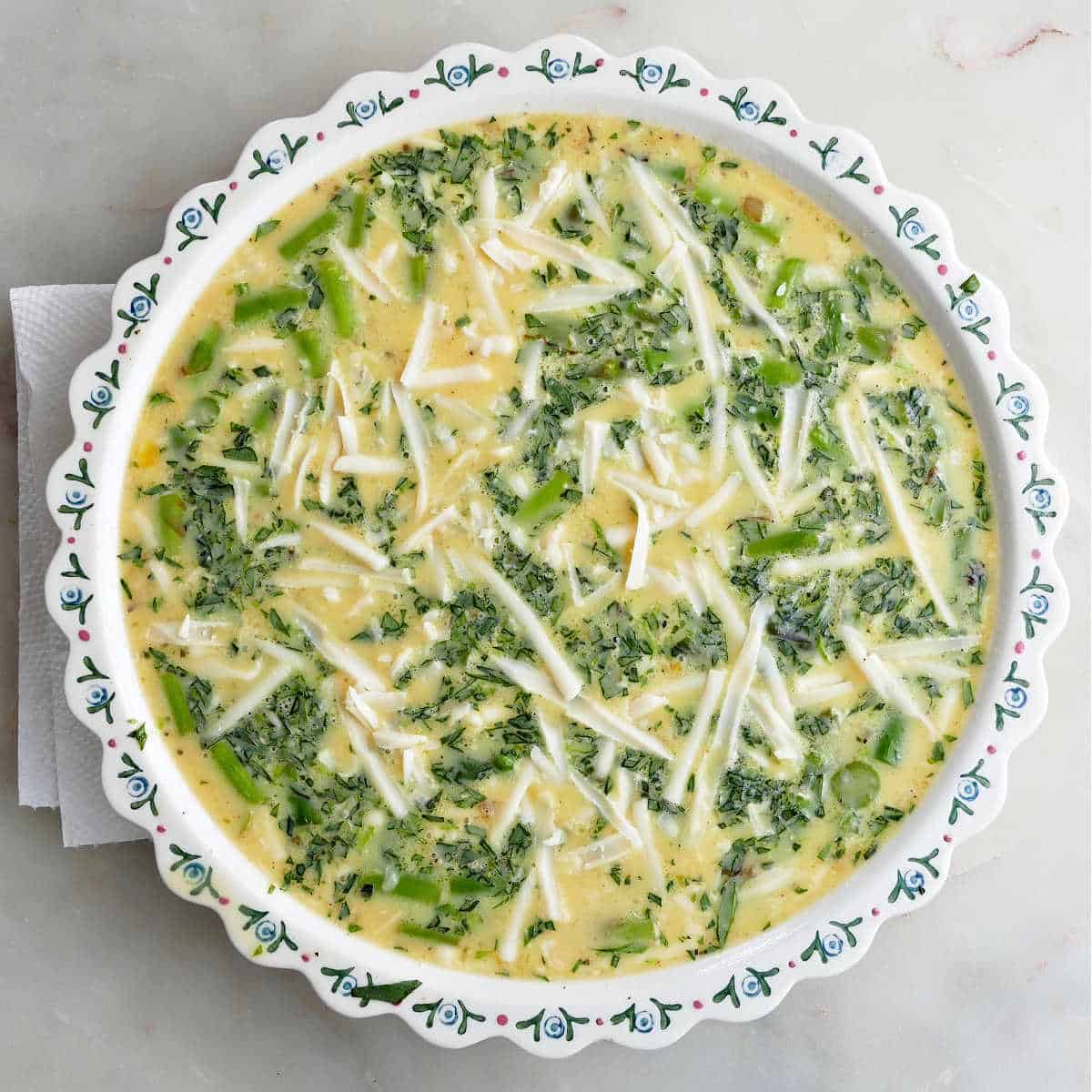 asparagus quiche in a pie plate before going into the oven