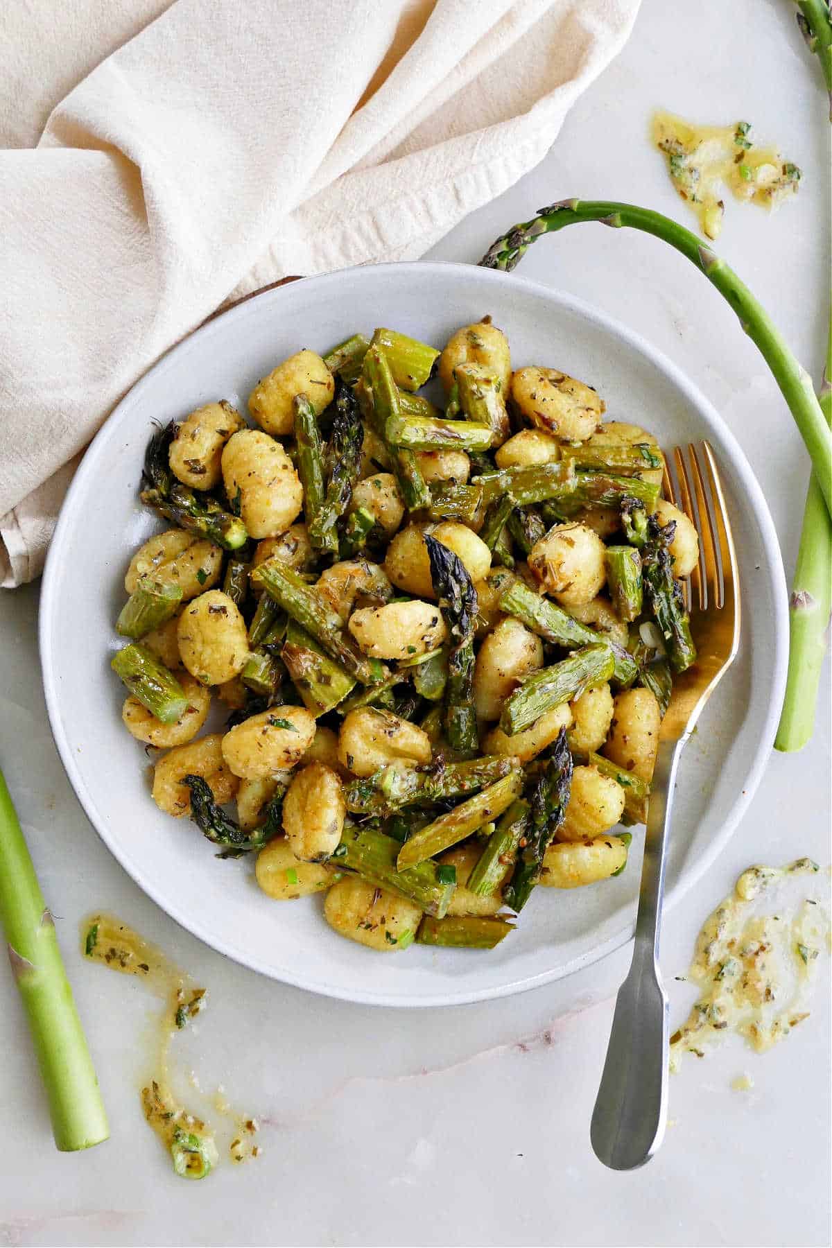 gnocchi with asparagus and lemon dressing on a serving plate with a fork