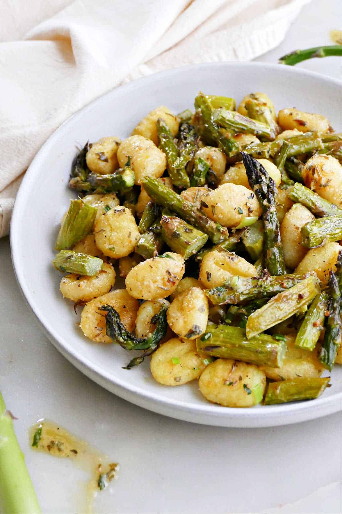 sheet pan asparagus and gnocchi with lemon tarragon dressing on a plate