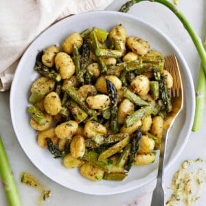 gnocchi with asparagus and lemon dressing on a serving plate with a fork