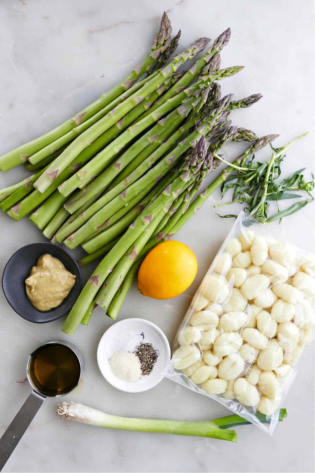 asparagus, tarragon, Meyer lemon, gnocchi, scallion, olive oil, and seasonings on a plate