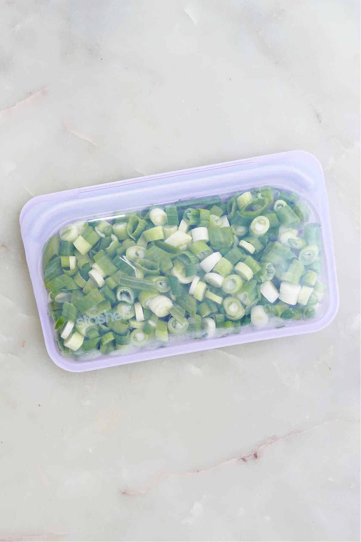 frozen green onions in a silicone freezer bag on a counter