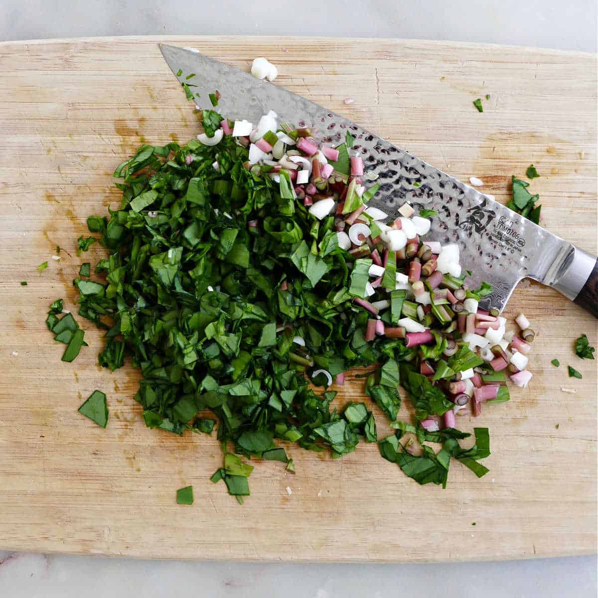 ramps cut up into pieces on a cutting board with a knife