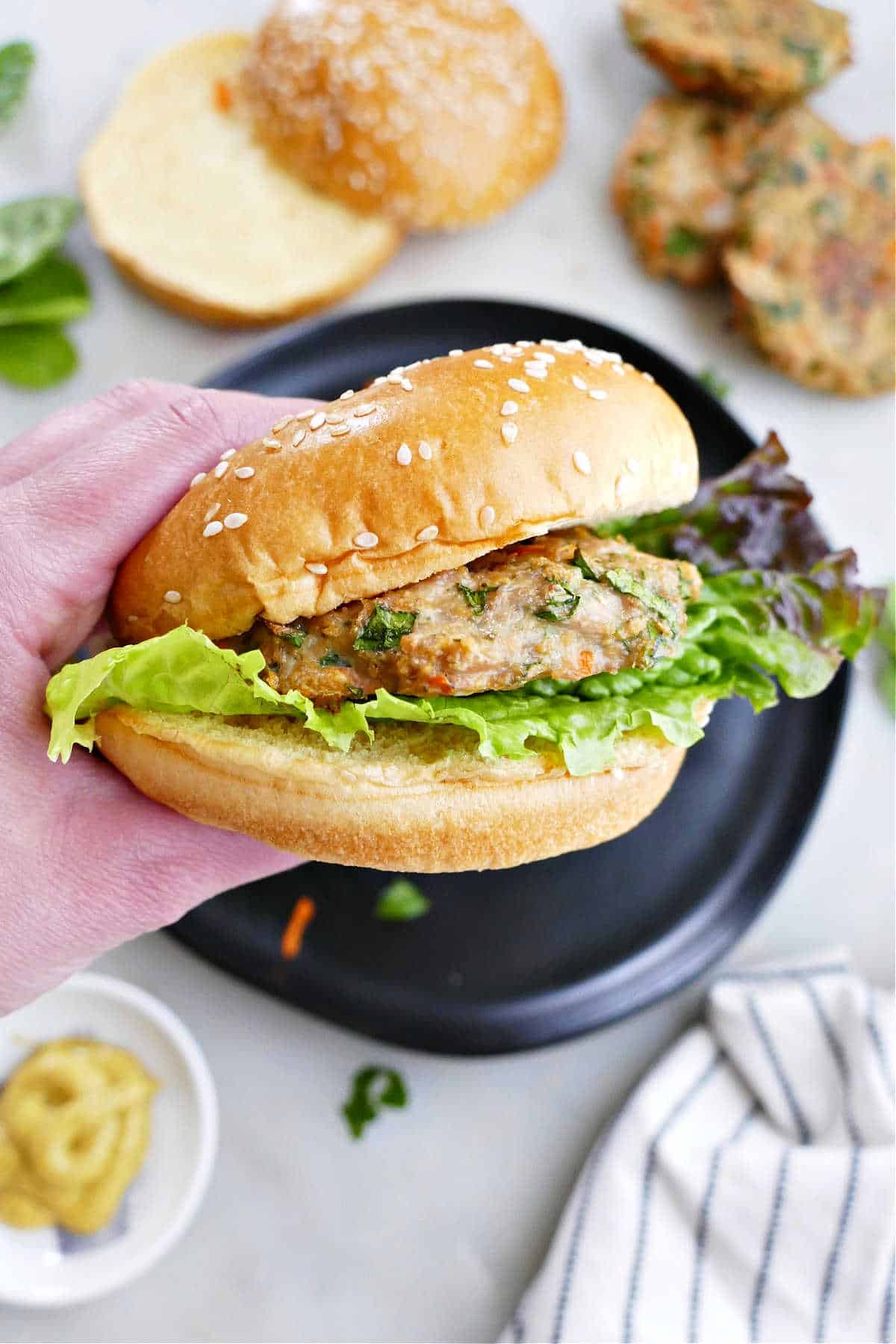 veggie chicken burger with lettuce being held in a woman's hand