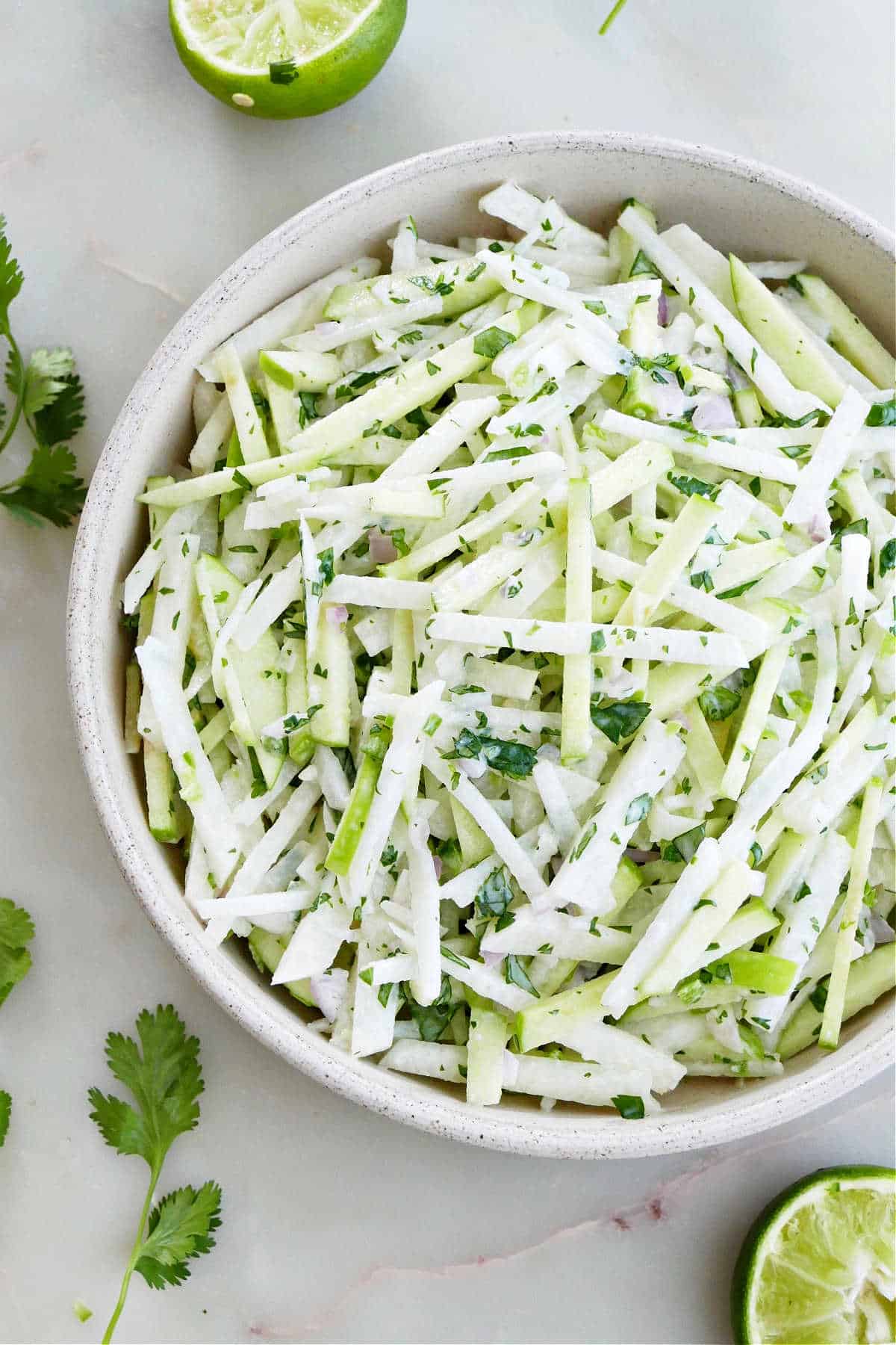 green apple, jicama, and jalapeño slaw in a serving bowl on a counter