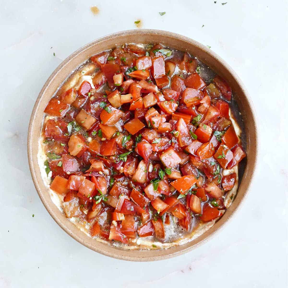 serving bowl with whipped cheese topped with cold bruschetta topping