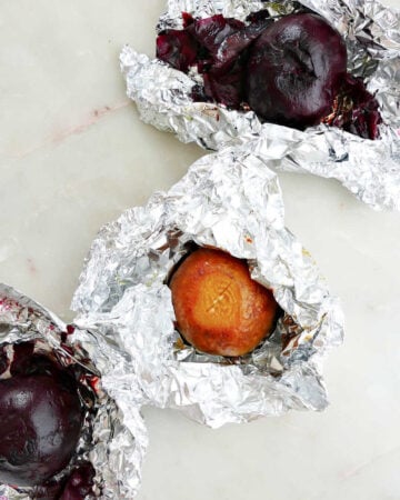 roasted beets in foil packets next to each other on a counter