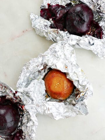 roasted beets in foil packets next to each other on a counter
