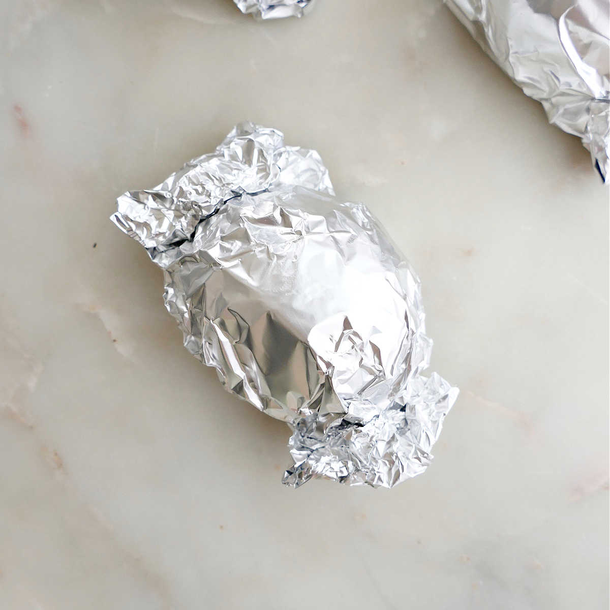 a beet wrapped in a foil packet before being roasted
