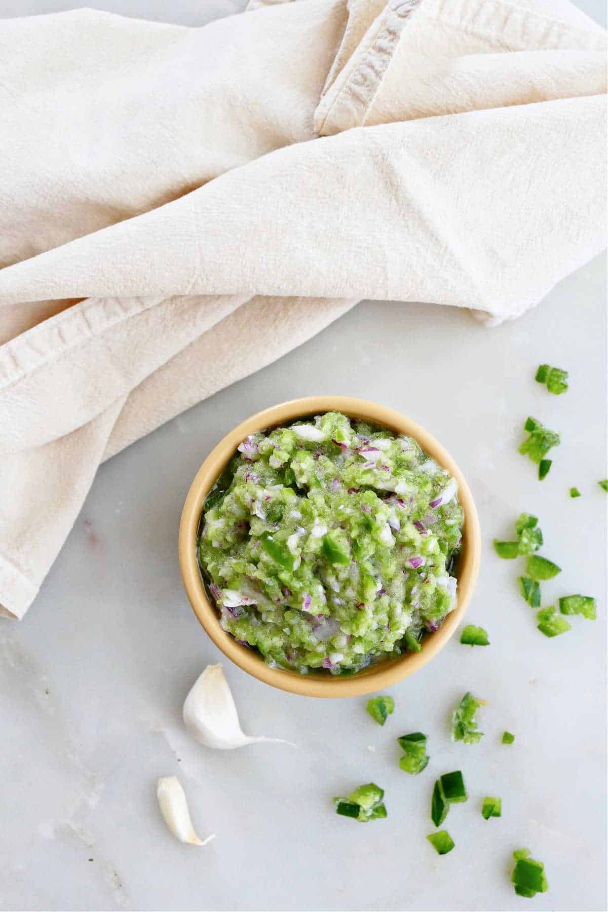 jalapeño relish in a bowl next to ingredients and a napkin on a counter