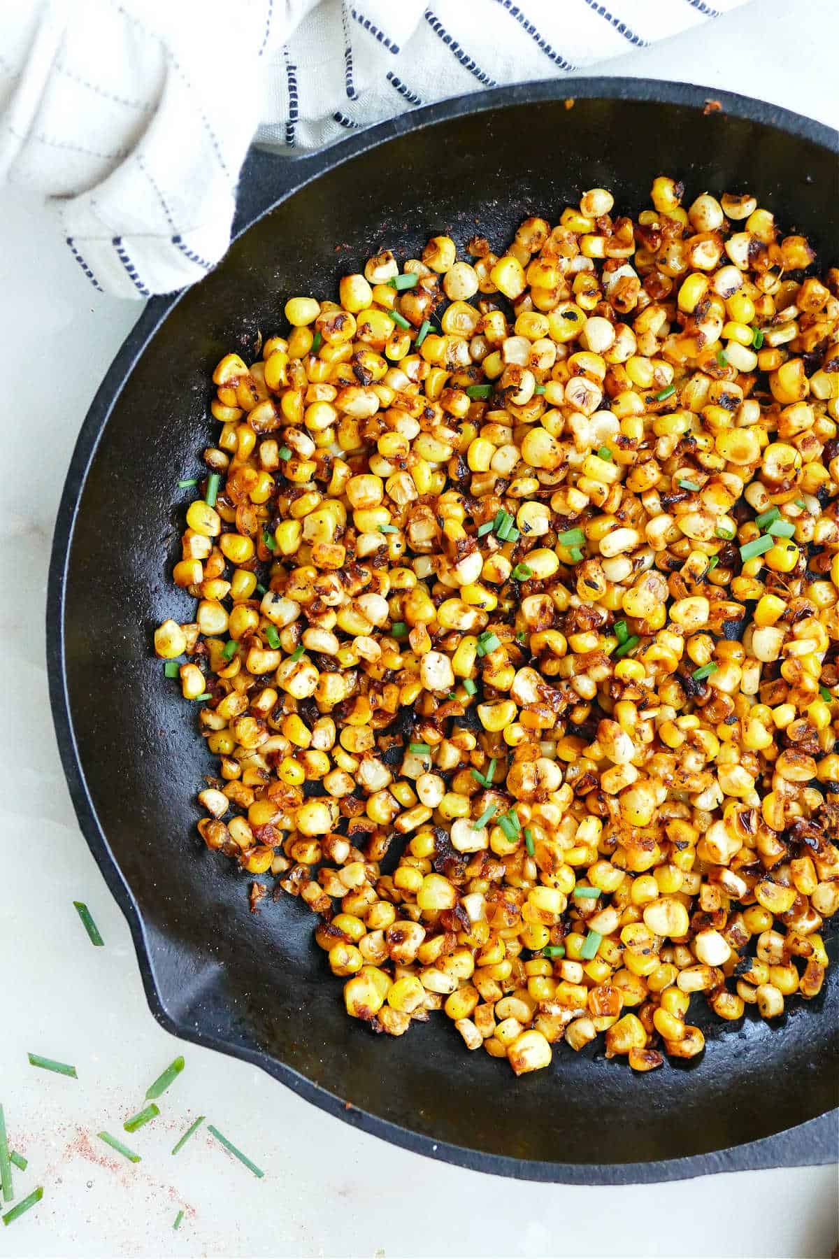 skillet charred corn with blackened seasoning in a skillet on a counter
